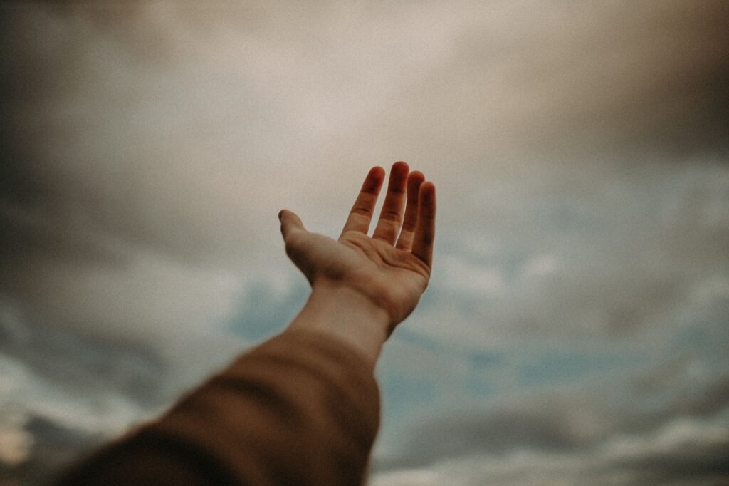 An open hand reaching up toward the sky, a gesture of surrender and dependence on God